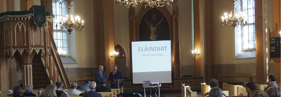 Kuva avajaisista kirkossa, jossa keskellä valkokangas, ja sivuilla näyttelyvieraita. Kuva ©: creation.com